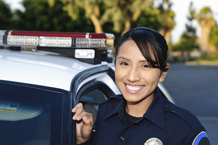 Female police officer standing next to vehicle