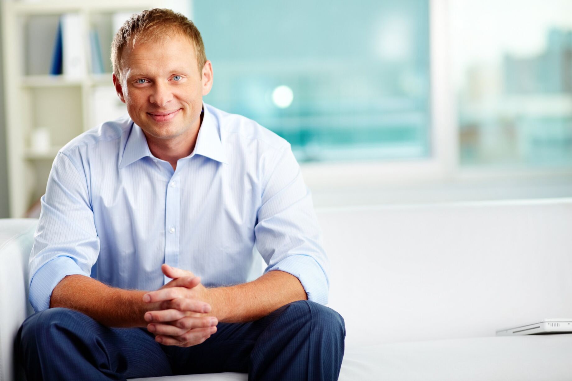 Sintelix sales consultant sitting on white couch